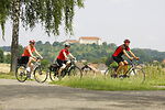Im Vordergrund drei Personen auf Fahrrädern - im Hintergrund Schloss Ellwangen